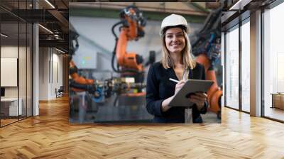 Female chief engineer in modern industrial factory using tablet and making audit. Wall mural