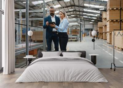 Female engineer and male production manager standing in modern industrial factory, talking about production. Manufacturing facility with robotics and automation. Wall mural