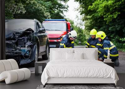 Firefighters helping a young injured woman after a car accident. Wall mural