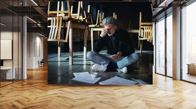 Frustrated owner sitting on floor in closed cafe, small business lockdown due to coronavirus. Wall mural