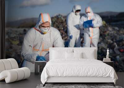 Group of activists with protective masks on landfill, environmental pollution concept. Wall mural