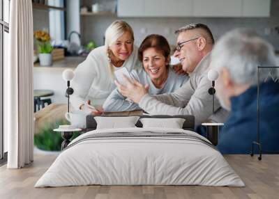 Group of senior friends at home, taking selfie. Wall mural