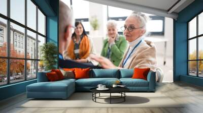 Group of senior people sitting in circle during therapy session, woman consoling depressed man. Wall mural