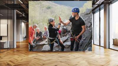 Group of seniors with instructor climbing rocks outdoors in nature, active lifestyle. Wall mural