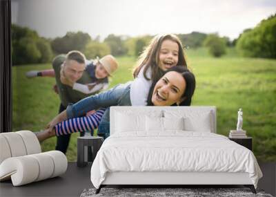 Happy family with two small daughters having fun outdoors in spring nature. Wall mural