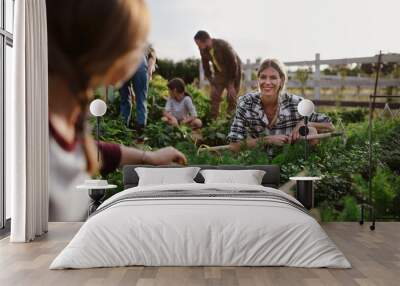 Happy farmers or gardeners working outdoors at community farm. Wall mural