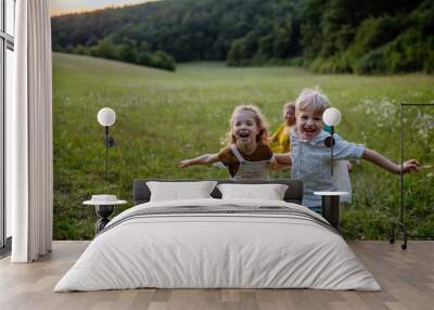 Happy young family spending time together outside in green nature. Wall mural