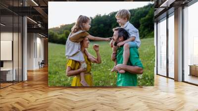 Happy young family spending time together outside in green nature. Wall mural