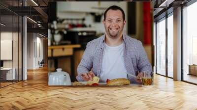 Independent man with down syndrome preparing brekfast in his apartment. Wall mural