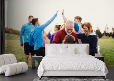 Large group of fit and active people resting after doing exercise in nature. Wall mural