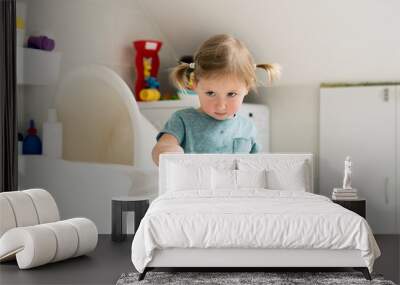 Little girl in bathroom cleaning bathtub with a brush. Wall mural