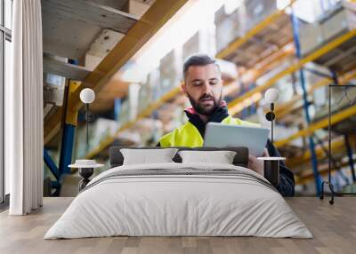 Male warehouse worker with tablet. Wall mural