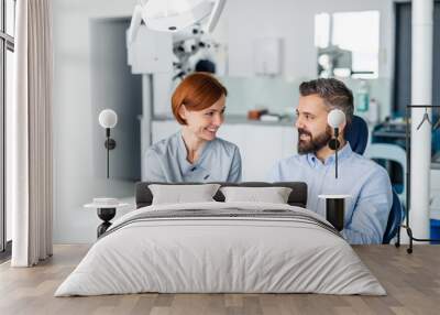 Man and dentist with tablet in dental surgery, annual check-up. Wall mural