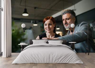 Man and woman having business meeting in a cafe, using laptop. Wall mural