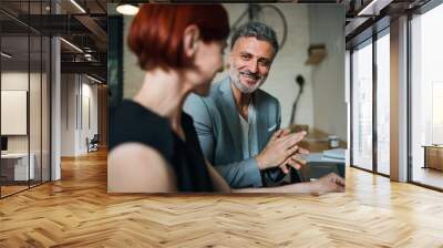 Man and woman having business meeting in a cafe, using laptop. Wall mural