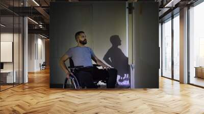 Man in wheelchair looking out of the window. Wall mural