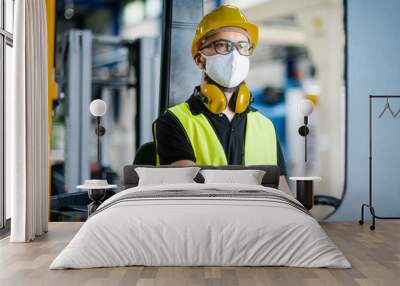 Man worker forklift driver with protective mask working in industrial factory or warehouse. Wall mural