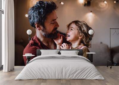 Mature father with small daughter standing indoors at home, holding and hugging. Wall mural