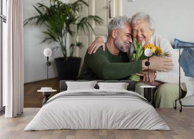 Mature man visiting his senior mother at her apartment. Wall mural