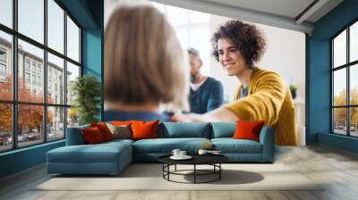 Men and women sitting in a circle during group therapy, supporting each other. Wall mural