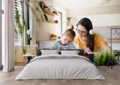 Mother and daughter learning indoors at home, Corona virus and quarantine concept. Wall mural