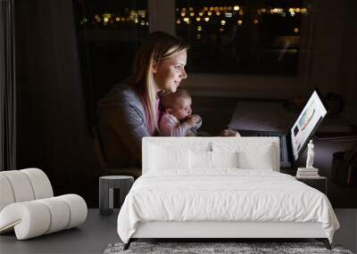 Mother with son in the arms, working on laptop Wall mural