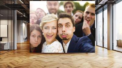 Newlyweds with friends taking selfie Wall mural