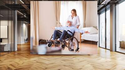 Nurse and senior man in wheelchair during home visit. Wall mural