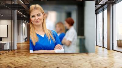 Portrait of beautiful female doctor standing in front of team of doctors. Colleagues, doctors team discussing patients diagnosis. Banner with copy space. Wall mural