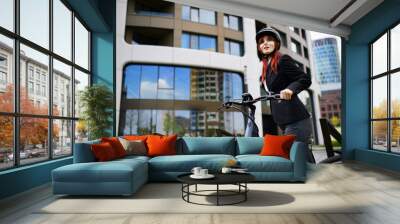 Portrait of businesswoman commuter on the way to work with bike looking at camera, sustainable lifestyle concept. Wall mural