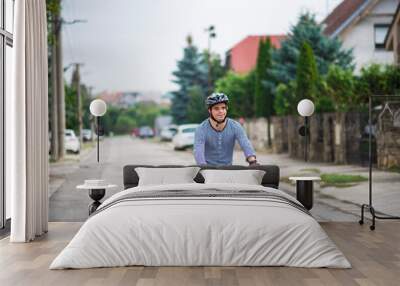 Portrait of down syndrome adult man with bicycle cycling outdoors on street. Wall mural