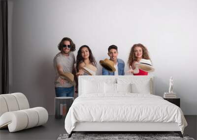 Portrait of joyful young group of friends with hats standing in a studio. Wall mural