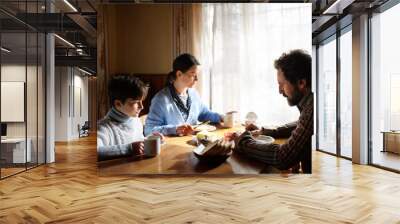 Portrait of poor sad small girl with parents eating indoors at home, poverty concept. Wall mural