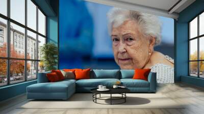 Portrait of scared senior patient on examination table in the hospital. Concept of fear and anxiety about health problems in elderly people. Wall mural