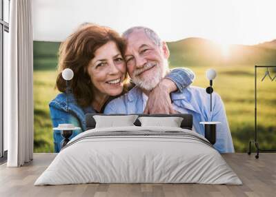 Senior couple outside in spring nature at sunset. Wall mural