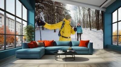 Senior couple skiing together in the middle of forest Wall mural