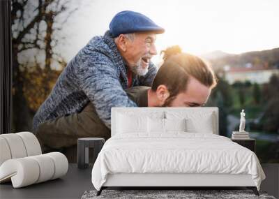 Senior father and his son walking in nature, having fun. Wall mural