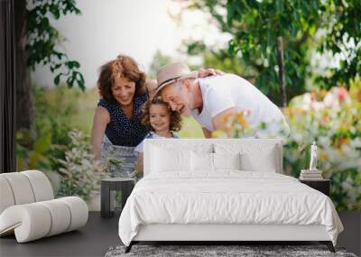 Senior grandparents and granddaughter gardening in the backyard garden. Wall mural