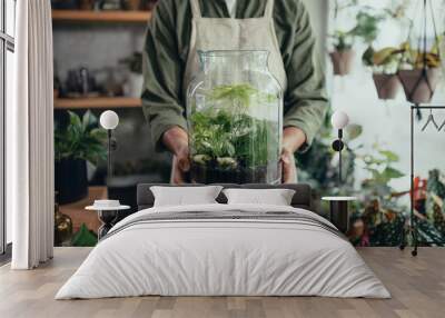 Shop assistant holding terrarium in indoor potted plant store, small business concept. Wall mural