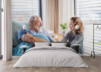 Small girl visiting ill grandfather in hospital room. Wall mural