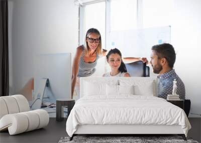 Three business people in the office talking together. Wall mural