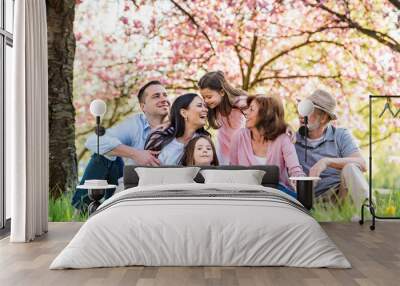 Three generation family sitting outside in spring nature. Wall mural