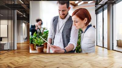 two young businesspeople using tablet in office, start-up concept. Wall mural