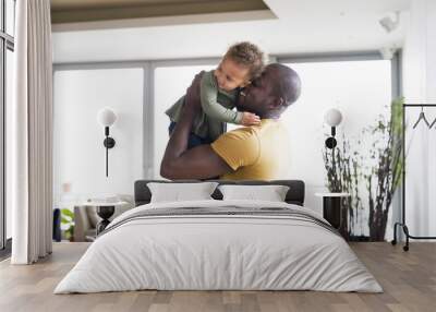 Young afro-american father with his little daughter at home. Wall mural