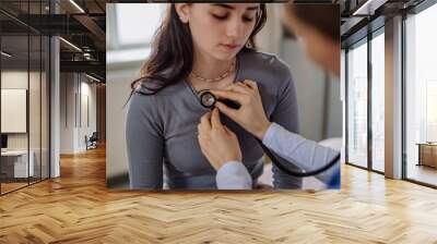 Young doctor examining teenage girl in her office. Wall mural