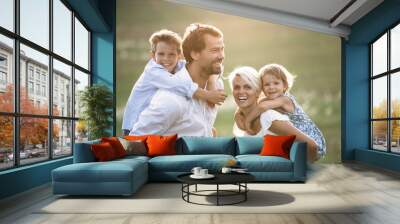 Young family with small children in summer nature at sunset. Wall mural