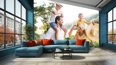 Young family with small children in sunny summer nature. Wall mural