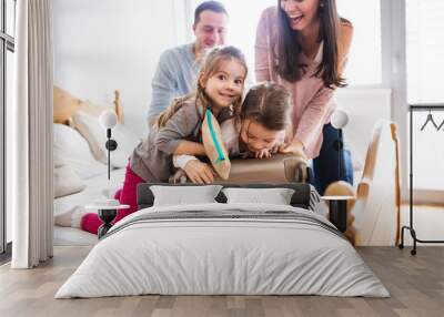 Young family with two children packing for holiday. Wall mural