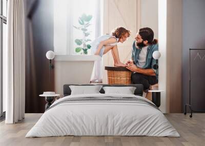 Young father painting small daugter's nails in a bathroom at home. Wall mural