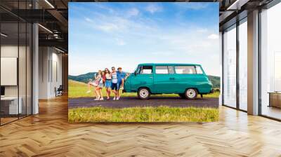 Young frieds with campervan, green nature and blue sky Wall mural